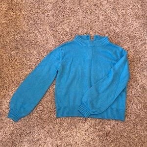 Blue cropped sweater with 4 buttons in the back.